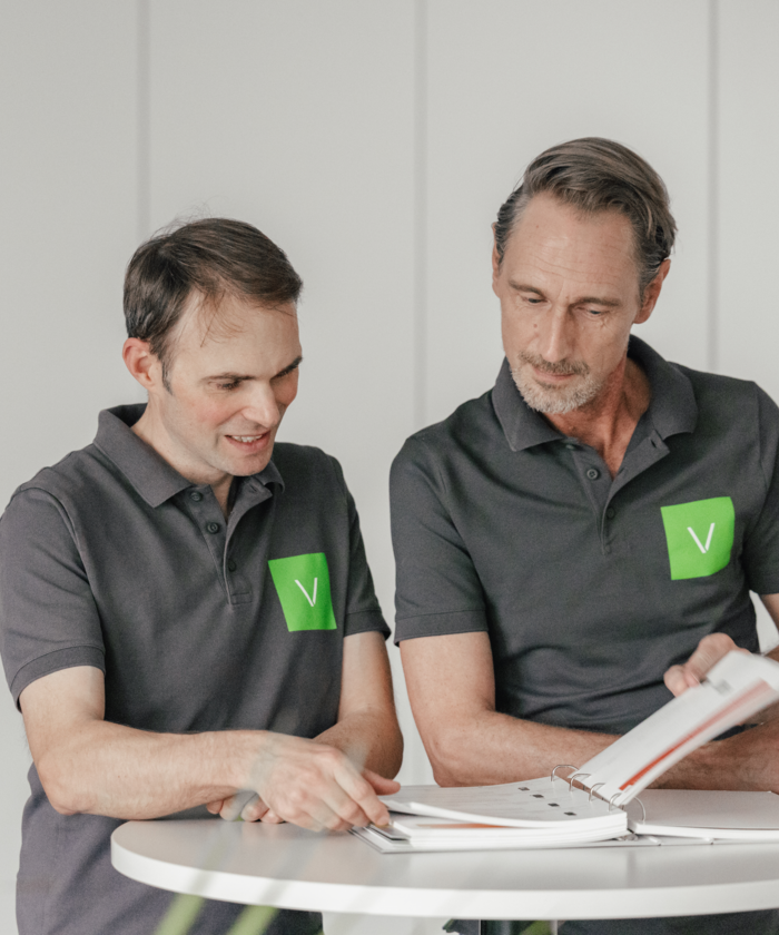 Zwei Vordermaier-Mitarbeiter im Gespräch über Unterlagen Zwei Vordermaier-Mitarbeiter im Gespräch über Unterlagen